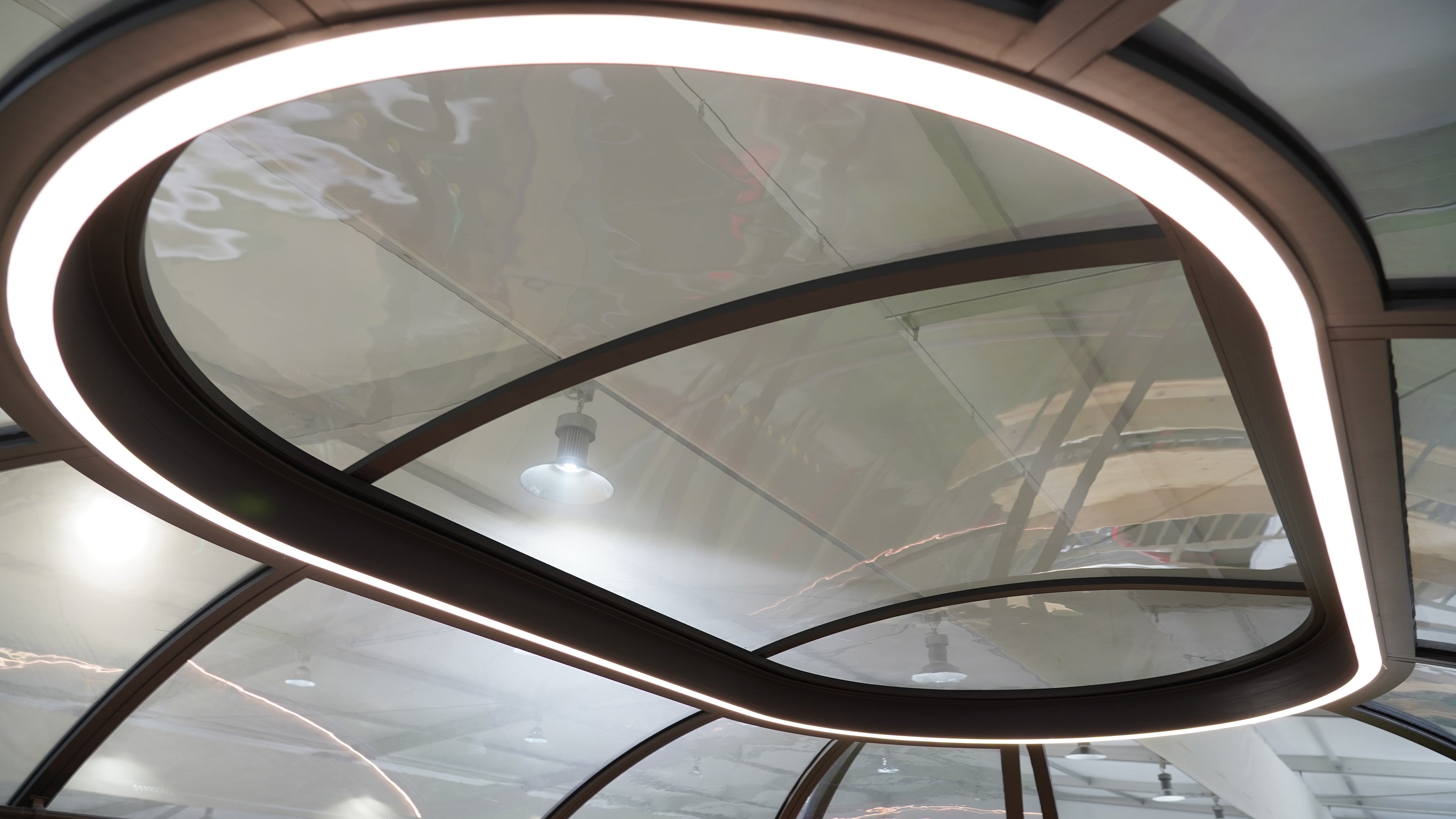 "Interior view of a modern geodesic dome with sleek, curved porthole windows, showcasing innovative design for luxury glamping solutions. Ideal for creating stylish and sustainable living spaces such as an artemis pod or backyard office."