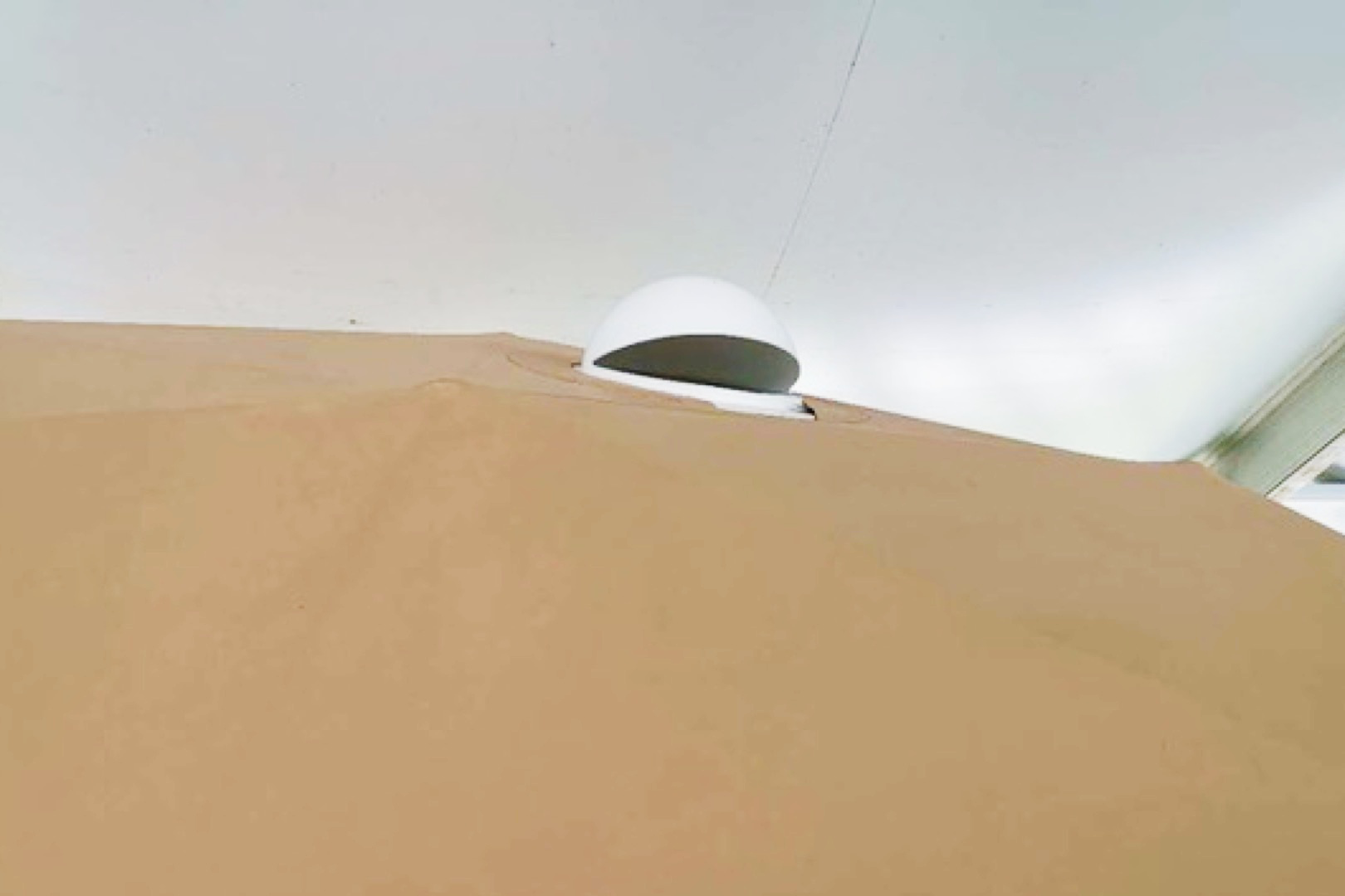 Alt text: "Close-up view of a geodesic dome tent with a porthole window, showcasing the durable fabric and modern design. Ideal for glamping, sustainable living, or creating a unique backyard space. Keywords: geodesic dome, porthole window, glamping pod."